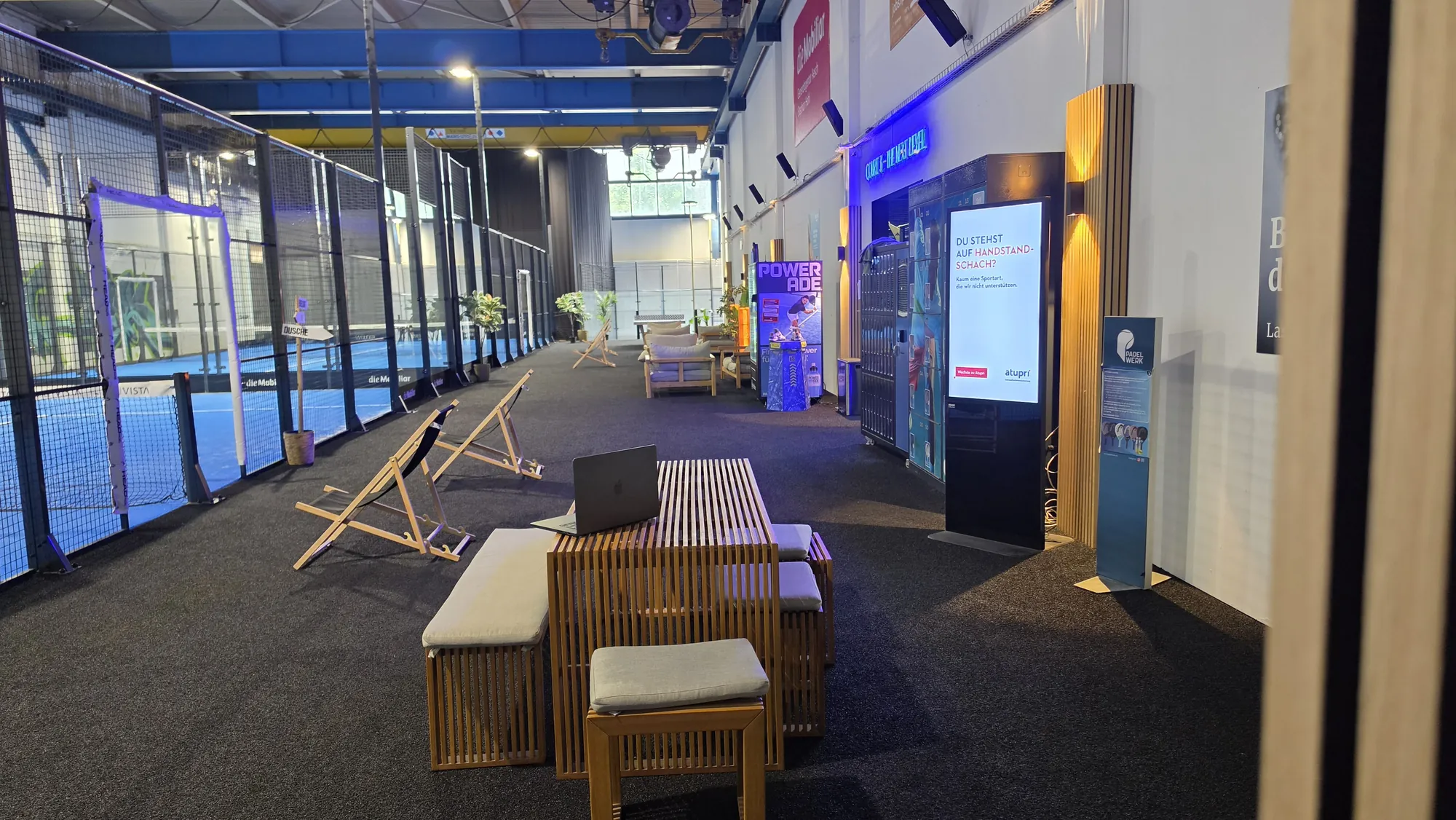 Lounge di un centro di padel con pubblicità Atupri sul totem della rete pubblicitaria DOOH