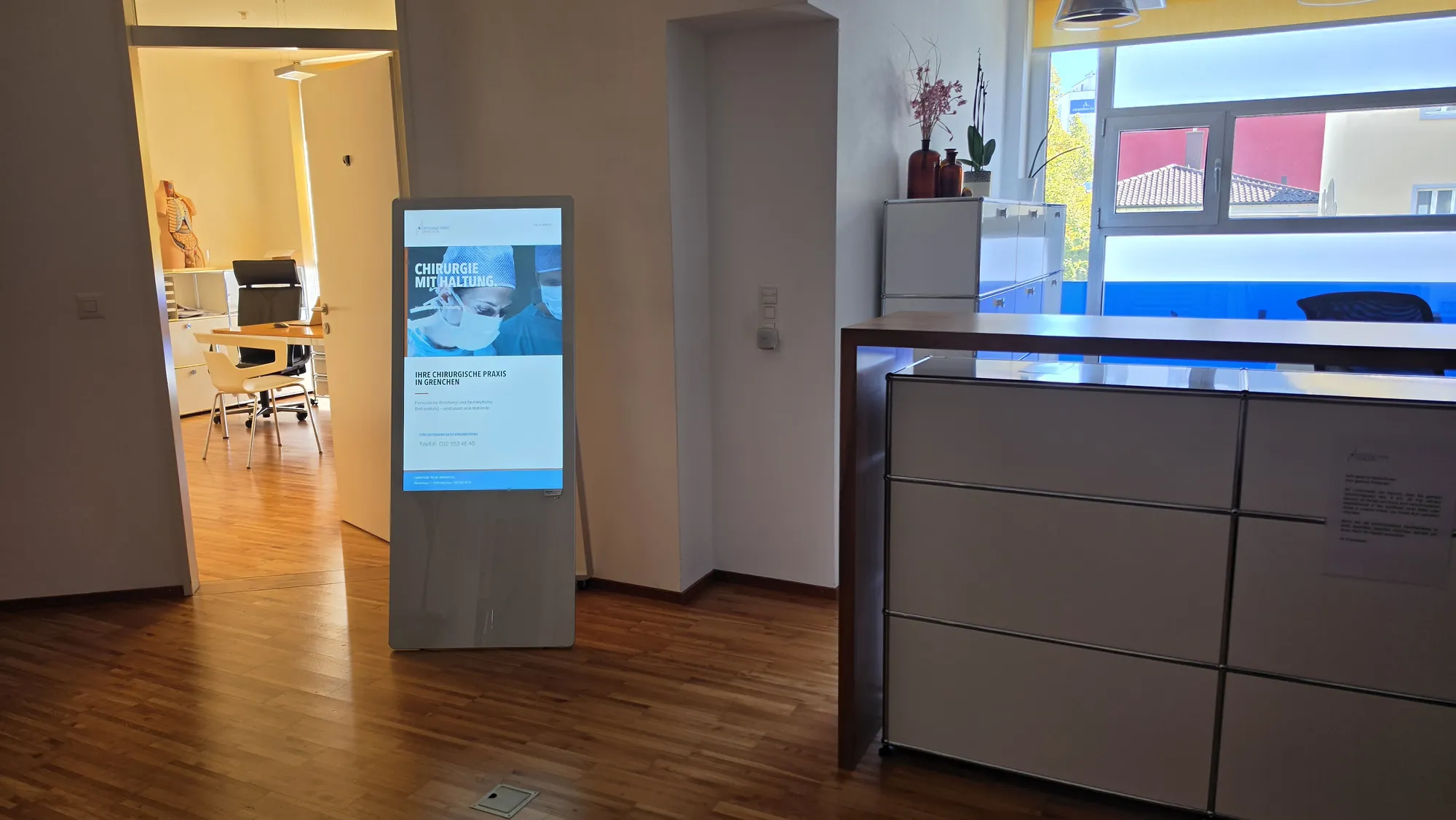 Digitaler Kundenstopper im Empfang des Chirurgie Team Grenchen mit «Chirurgie mit Haltung»