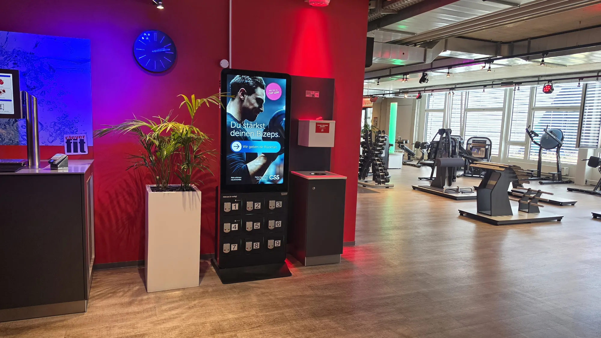 CSS design «Du stärkst deinen Bizeps.» (you build your biceps) on a totem next to the counter in the gym