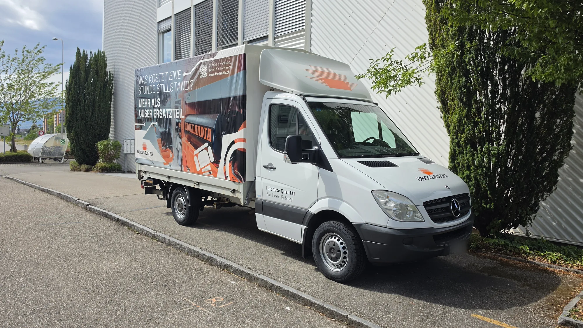 Pritschenwagen der Dhollandia AG mit bedruckter Blache «Was kostet eine Stunde Stillstand?»