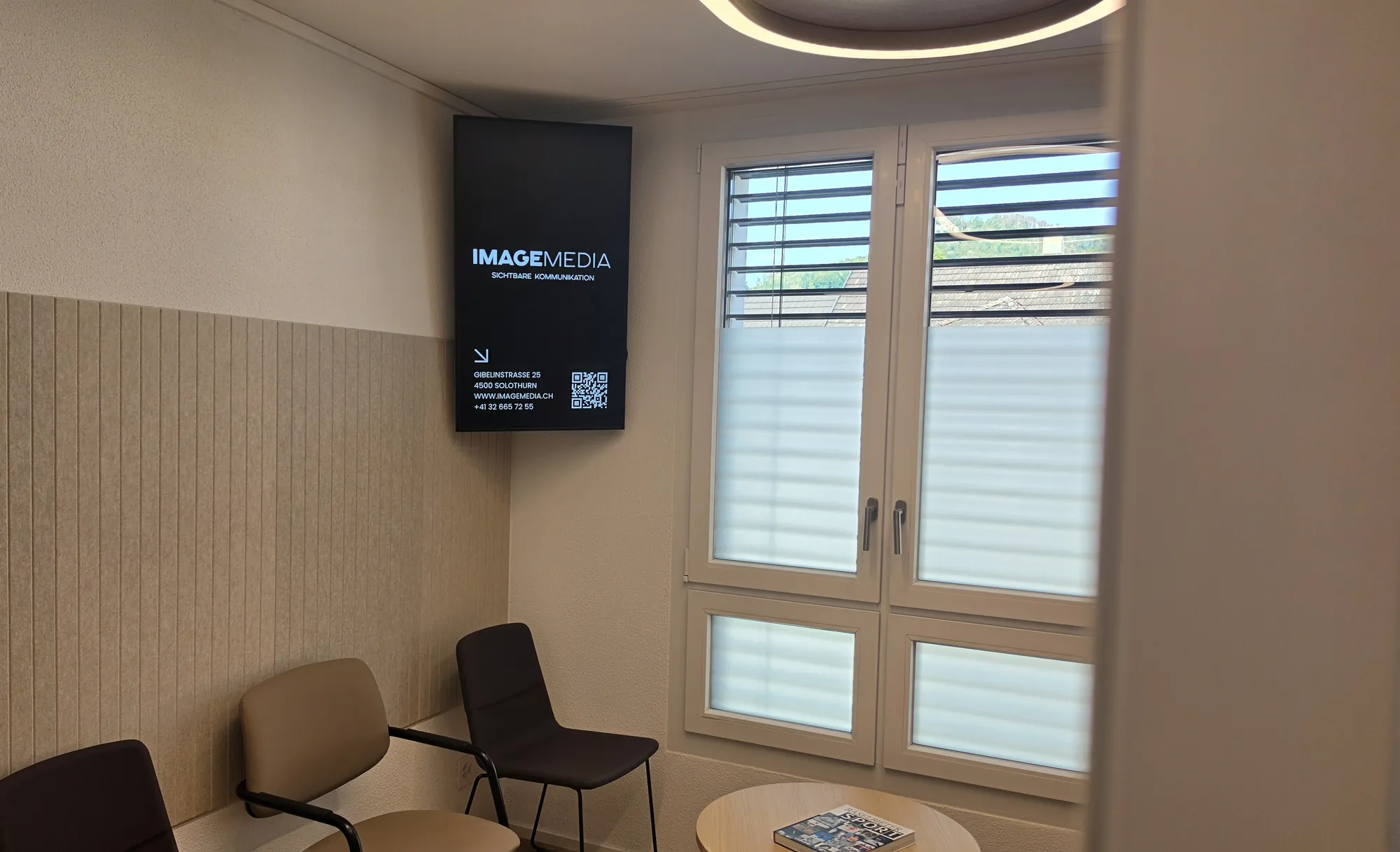 Hochformat-Screen in der Ecke eines Wartezimmers von SissaMed in Sissach
