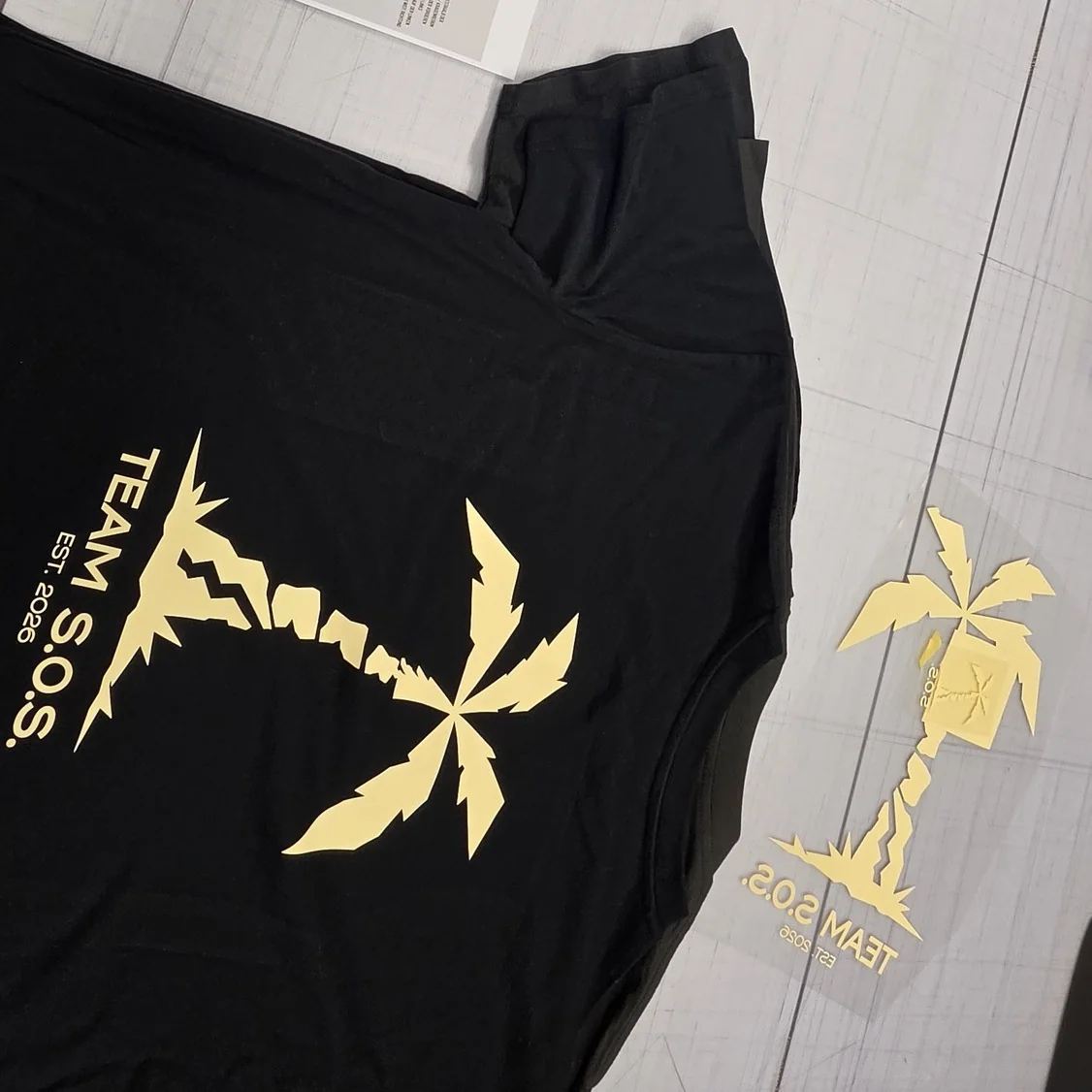 Camiseta impresa de Team S.O.S. junto al vinilo flex cortado sobre su soporte